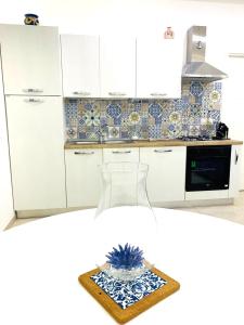 a kitchen with white cabinets and a vase on a table at Donn'Anna Naples City Center in Naples