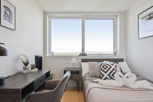 a living room with a couch and a desk and two windows at Luxury 3-Bed Apt in Wembley Park in London +36 photos