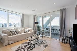 a living room with a couch and large windows at Luxury 3-Bed Apt in Wembley Park in London