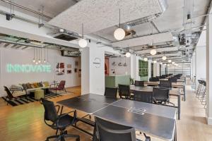 a group of tables and chairs in a room at Luxury 3-Bed Apt in Wembley Park in London