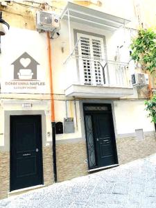 a building with two black doors on a street at Donn'Anna Naples City Center in Naples