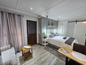 Stylish Cozy Stay at Ferndale House Apartments في بورت ألفريد: غرفة نوم مع سرير وغرفة معيشة