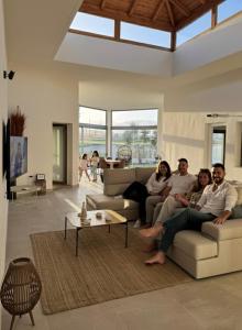 a group of people sitting on a couch in a living room at Villa Atlantic Breeze in Antigua