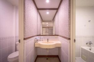 a bathroom with a sink and a toilet and a mirror at Mesasa Garden Motel in Ji'an