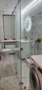 ein Badezimmer mit Dusche und Waschmaschine in der Unterkunft Spacious appartment in green area, 5 km to Khreschatyk in Kiew