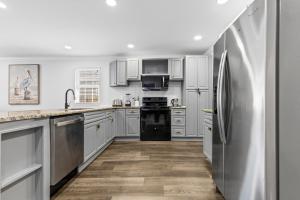 a kitchen with white cabinets and a stainless steel refrigerator at Bright and Modern Close to Everything in Charlotte +46 photos