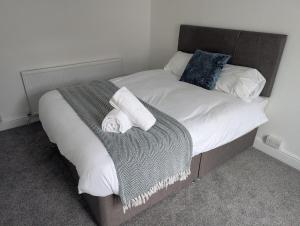 ein Bett mit zwei Handtüchern und einer Decke darauf in der Unterkunft Spacious 3BR Swansea House near City Centre in Swansea