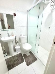 a bathroom with a toilet and a sink and a shower at Suite aconchego Belém in Una +24 photos