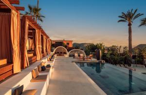 a resort with a swimming pool and palm trees at Hotel Estefania Boutique Suites in Chayofa