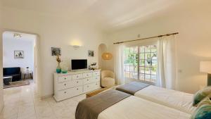 a bedroom with a large bed and a television at Villa Verde by Check-in Portugal in Vilamoura