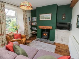 a living room with a couch and a fire place at Centenary Cottage in Skipton