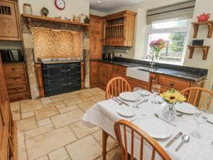 a kitchen with a table with a white table cloth at Centenary Cottage in Skipton