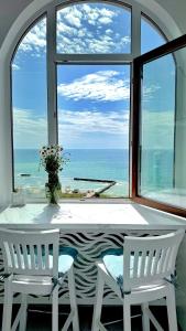 a table and two chairs in front of a large window at Вид на море, ЖК Avinion in Odesa