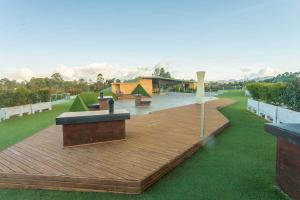 a wooden deck with benches on top of a field at Hotel Rioverde-Suite localizada a 5 minutos del aeropuerto Internacional in Rionegro