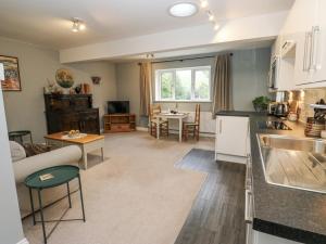 a kitchen and living room with a couch and a table at The Treetop in Settle