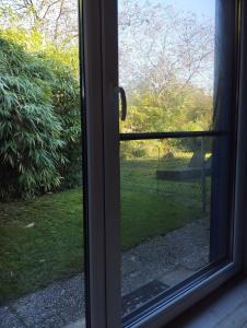 a window with a view of a park seen through it at Kleinere Doppelhaushälfte in Stadtkernnähe von 47506 Neukirchen-Vluyn inklusive Küche in Neukirchen-Vluyn