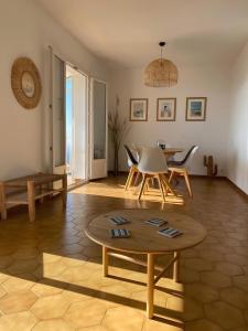 a living room with a table and chairs at Maison tout confort in Cervione