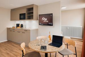 a dining room with a table with a laptop on it at Stay Sunday in Zurich