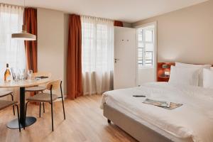 a hotel room with a bed and a table and a table and chairs at Stay Sunday in Zurich