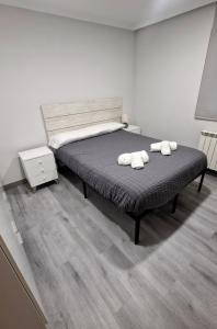 een slaapkamer met een bed met twee handdoeken erop bij Aloja Burgos in Burgos