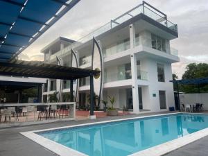 a large white building with a swimming pool at The Views Resort in El Zonte