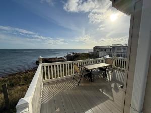 ニュービギン・バイ・ザ・シーにあるNo13 Seaview Holiday Homeの海を望むデッキ(テーブル、椅子付)