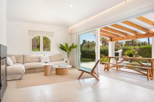 a living room with a couch and a table at Melodie home Menorca in Sa Caleta
