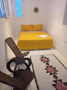 タンジェにあるcasa zeitunaのベッドルーム1室(ベッド1台、椅子、ラグ付)