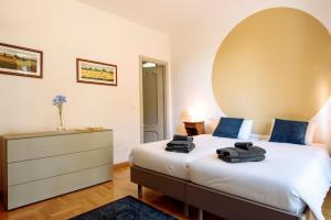 a bedroom with a large white bed with blue pillows at La Collina di Cesare in Calosso