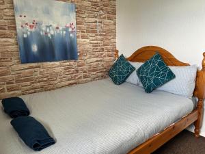 Una cama con dos almohadas encima en una habitación. en Ty Abertawe, en Cockett