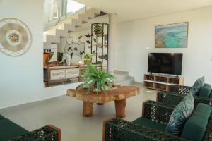 un salon avec une table et des chaises dans l'établissement Casa em Milagres/AL | 3 suítes, vista-mar, piscina, à Barra do Camaragibe