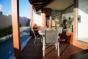 un balcon avec une table et des chaises à côté d'une piscine dans l'établissement Casa em Milagres/AL | 3 suítes, vista-mar, piscina, à Barra do Camaragibe