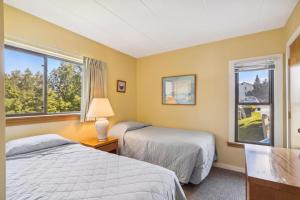 Dos camas en una habitación con dos ventanas. en Pinnacle E09, en Killington Village 12 fotos más