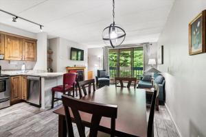 Una cocina y una sala de estar con mesa y sillas. en Pinnacle E12, en Killington Village