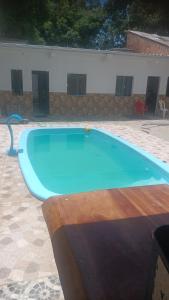 a large blue swimming pool in a yard at Espaço Marques com ar in Porto Seguro