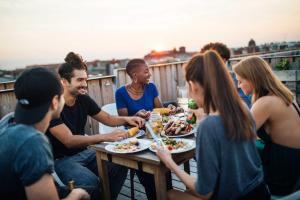 a group of people sitting around a table eating food at Magic Moments - London Bridge - by Frankie Says in London
