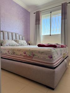 イフレンにあるCozy & Affordable Family Apartmentの窓付きのベッドルームの大型ベッド1台 +1枚の写真