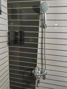 a shower with a shower head on a wall at Ghumakkads Hostel Near IGI Airport & Aerocity in New Delhi