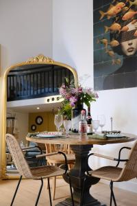 - une salle à manger avec une table, des chaises et un miroir dans l'établissement La cour d Anvers, à Dieppe