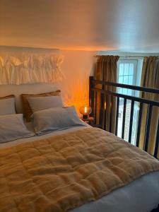 a large bed in a bedroom with a window at La cour d Anvers in Dieppe
