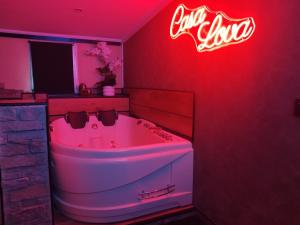 a neon coca cola sign in a bathroom with a tub at Casa Lova Spa Privé, Clim,Baignoire balnéo in Entraigues-sur-la-Sorgue +7 photos