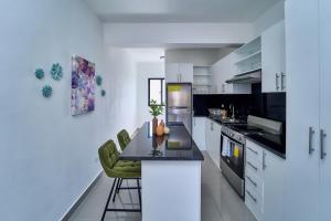 a kitchen with white cabinets and a table and chairs at Cozy Nest in La Romana