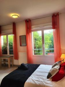a bedroom with a bed with red curtains and a window at Studio - Piscine, proche du golf in Juvignac