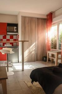 a living room with a table and a kitchen at Studio - Piscine, proche du golf in Juvignac