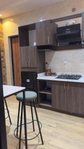 a kitchen with wooden cabinets and a table and a stove at Zuwa Apartments Rental Home in Baruwa
