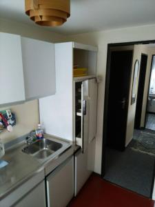 a small kitchen with a sink and a refrigerator at Haus Küstenglück in Neuharlingersiel +2 photos