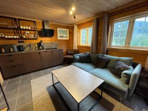 a living room with a couch and a table at Small cabin at Seljestad in Utsikten