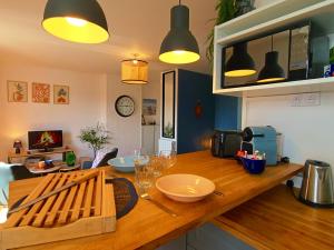 a kitchen with a wooden counter with wine glasses on it at L'Alcôve de l'Olivier - Studio cosy proche gare in Caen +16 photos