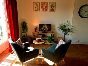a living room with two chairs and a table at L'Alcôve de l'Olivier - Studio cosy proche gare in Caen