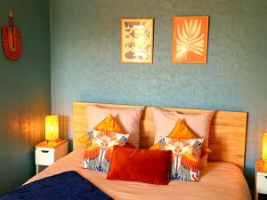 a bedroom with a bed with orange and blue at L'Alcôve de l'Olivier - Studio cosy proche gare in Caen